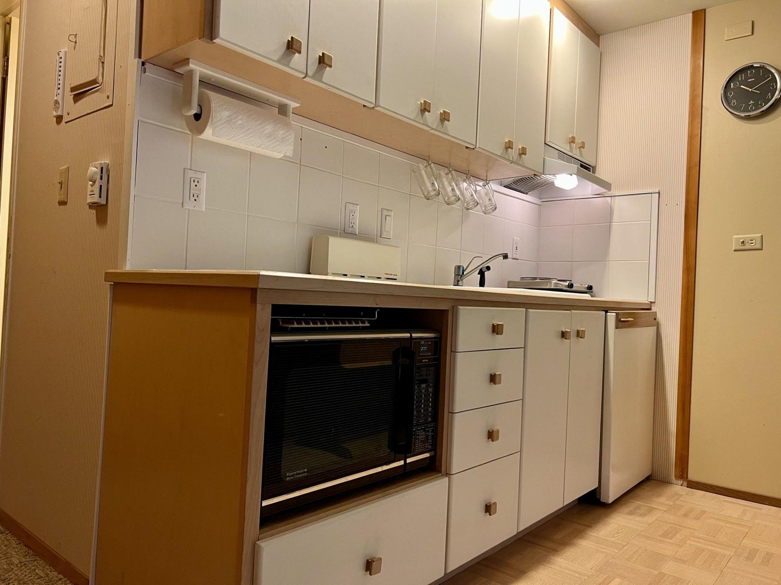 Kitchen with microwave, cooktop and cabinets